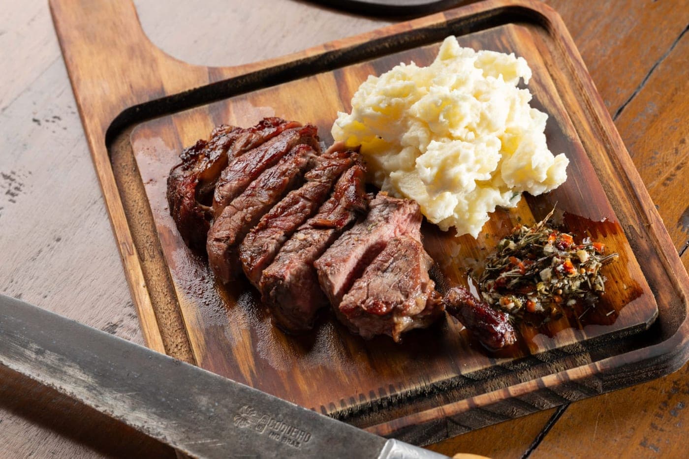 Prato de picanha fatiada com purê, servido em evento de buffet de churrasco